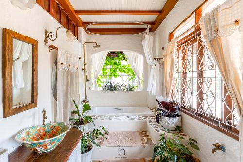 a bathroom with a tub and a sink and windows at Naturetalk Homestay in Ban Don