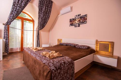 a bedroom with a bed and a large window at Napvirág-Ház in Zsira