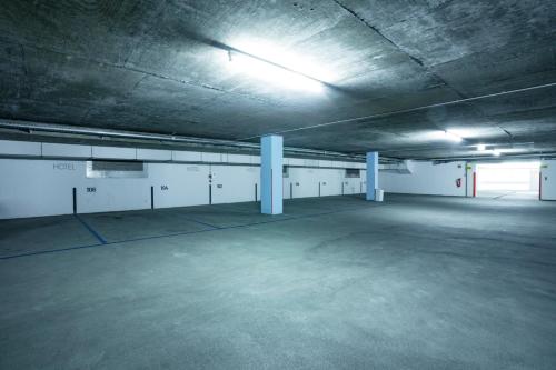 an empty parking garage with a light on the ceiling at Garner Hotel Berlin - Spandau by IHG in Berlin