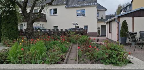 a garden in front of a house with flowers at Ferienhaus Köhler in Marienberg