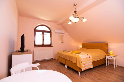 a bedroom with a bed and a tv in it at Napvirág-Ház in Zsira