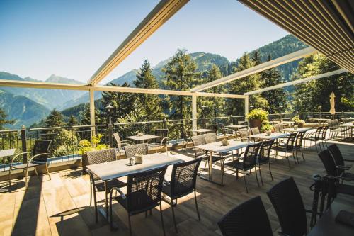un restaurante con mesas y sillas con montañas al fondo en die Aussicht en Finkenberg