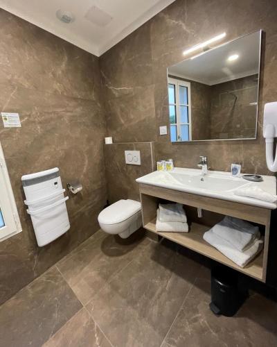a bathroom with a sink and a toilet and a mirror at Le Clos Du GALION - Ile de Ré in Saint-Martin-de-Ré