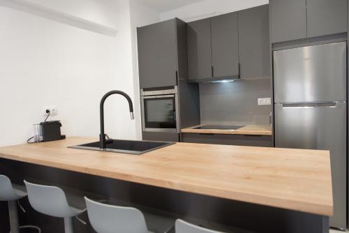 cocina con encimera de madera y nevera de acero inoxidable en L apartment2 en Atenas