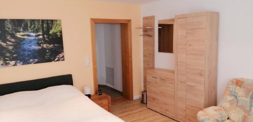 a bedroom with a bed and a dresser and a closet at Ferienhaus Köhler in Marienberg