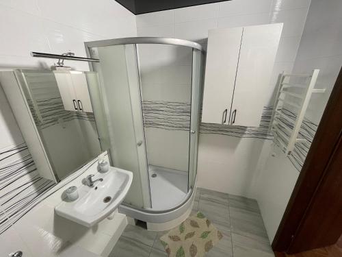 een witte badkamer met een douche en een wastafel bij Квартира в новому будинку in Kiev