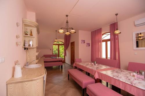 un salón con mesas rosas y sillas rosas en Napvirág-Ház en Zsira
