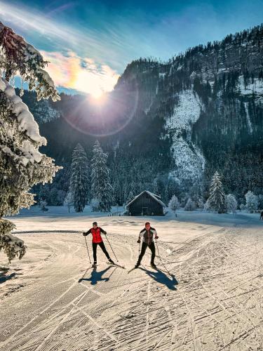 two people are skiing down a snow covered slope at Hotel Goldener Ochs in Bad Ischl