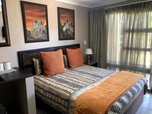 una camera da letto con un grande letto con cuscini arancioni di Klein Kavali Studio's a Eikenhof