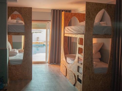 a room with two bunk beds and a pool at Ericeira Destination in Ericeira