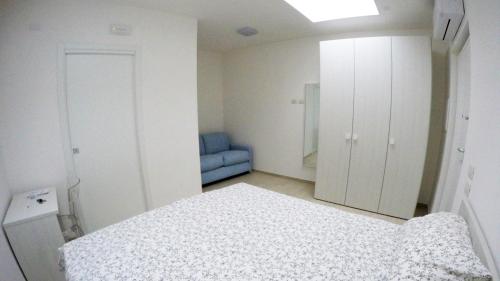 耶西的住宿－Corso95 SrL，白色卧室配有床和蓝椅