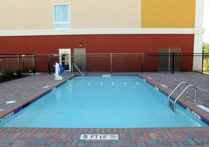 a large blue swimming pool in front of a building at Comfort Suites near Tanger Outlet Mall in Gonzales