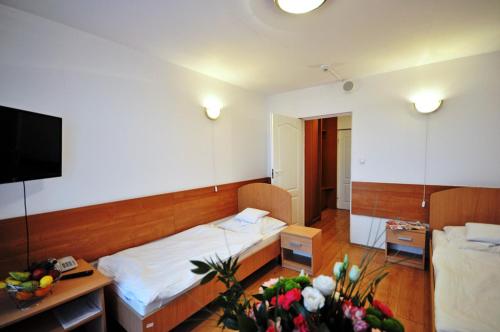 a bedroom with a bed and a desk with flowers at SP ZOZ Sanatorium Uzdrowiskowe MSWiA w Kołobrzegu in Kołobrzeg