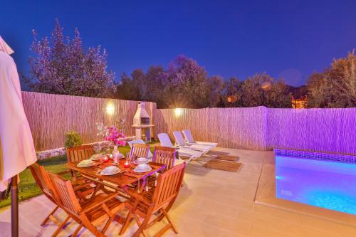 a patio with a table and chairs and a swimming pool at Villa Grando 2 in Kas