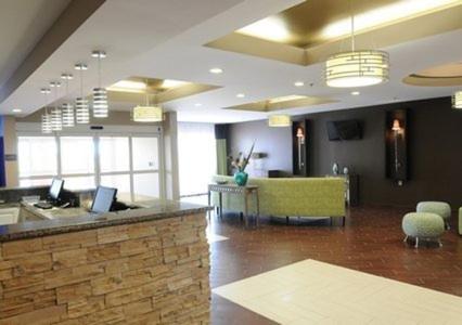 a lobby with a reception desk and a green couch at Comfort Suites near Tanger Outlet Mall in Gonzales