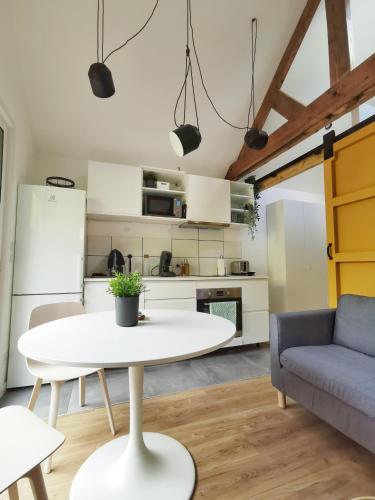 Il comprend une cuisine et un salon avec une table blanche et un canapé. dans l'établissement Au Mexico (Centre - Gare - Atypique - Parking), à Béthune