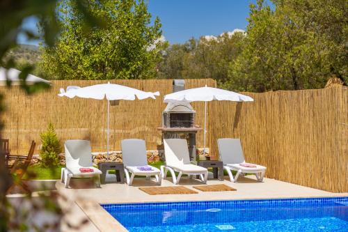 a group of chairs and umbrellas next to a pool at Villa Grando 2 in Kas