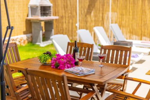 a wooden table with two glasses of wine and flowers at Villa Grando 2 in Kas