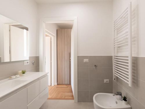 a white bathroom with a sink and a mirror at The Best Rent - Bright apartment near Isola Tiberina in Rome