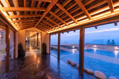 a house with a swimming pool with a wooden ceiling at Taj Theog Resort & Spa Shimla in Shimla