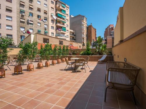 a patio with tables and chairs and buildings at Limehome Barcelona Carrer de Besalú 82 in Barcelona