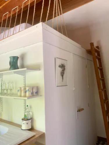 a white staircase in a room with a shelf at Gîtes du Puyjovent - Côté Forêt - à 15 minutes de Crest, vue panoramique, calme in Piégros-la-Clastre