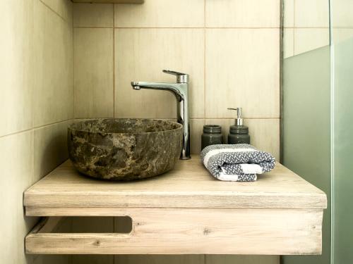 baño con lavabo y un gran tazón de piedra. en ANCIENT MEROPIA - Eden en Apollonía