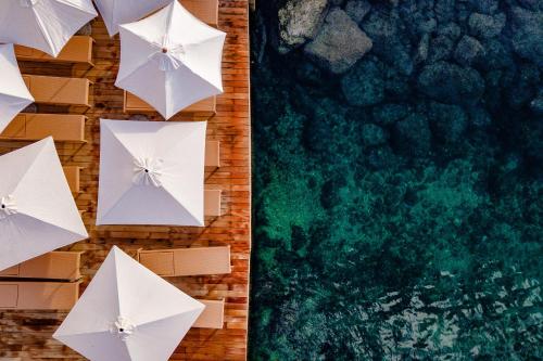 eine Draufsicht auf weiße Regenschirme an einer Wand in der Unterkunft Hotel Istra - Liburnia in Opatija