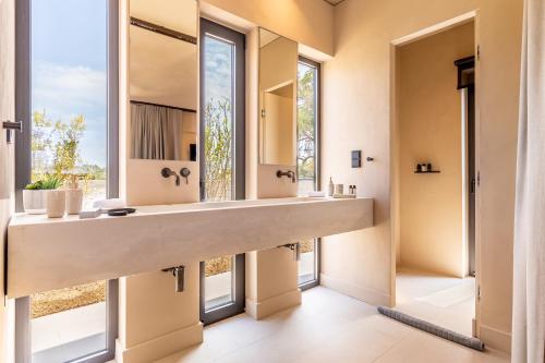 a bathroom with a large sink and large windows at Paloubi Estate in Sinarádes