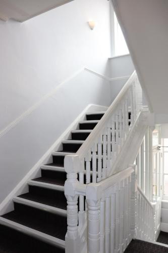 a staircase with white railings and a white stair case at Plough Hotel in Northampton