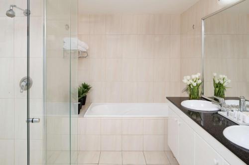 bagno con vasca, 2 lavandini e doccia di Rydges Hotel Port Macquarie a Port Macquarie