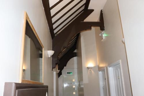 a hallway with a stairway leading into a building with a wooden stair case at Plough Hotel in Northampton