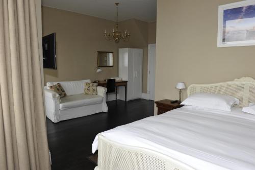um quarto com uma cama, um sofá e uma cadeira em Suenos Guesthouse em Southend-on-Sea