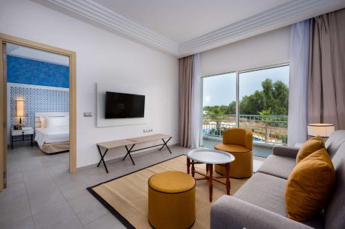 a living room with a couch and a bed at Radisson Blu Resort, Saidia Garden in Saidia 