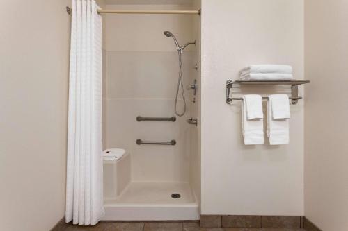 y baño con ducha, aseo y toallas. en Baymont by Wyndham Hutchinson, en Hutchinson