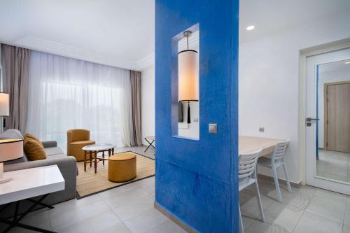 a living room and dining room with a blue wall at Radisson Blu Resort, Saidia Garden in Saidia 