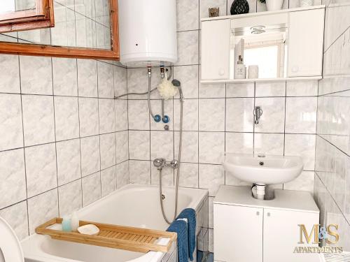 uma casa de banho com um lavatório, uma banheira e um WC. em Matija Apartment em Novi Sad