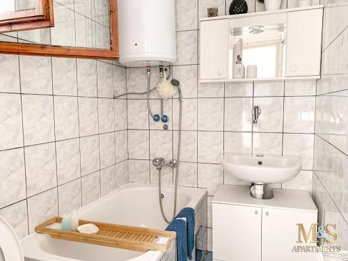 a bathroom with a sink and a tub and a toilet at Matija Apartment in Novi Sad