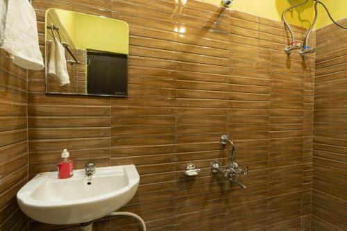 La salle de bains est pourvue d'un lavabo et d'un miroir. dans l'établissement Zostel Homes Harabhag, Jogindernagar, à Bir