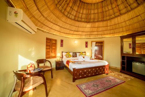 a bedroom with a large bed and a large ceiling at Bhavya Resort - Luxury Boutique Desert Camp in Jaisalmer