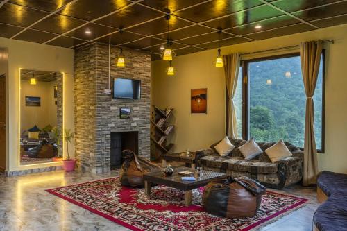 a living room with a couch and a fireplace at Zostel Homes Harabhag, Jogindernagar in Bīr