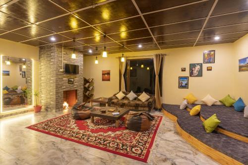 a living room with a couch and a fireplace at Zostel Homes Harabhag, Jogindernagar in Bīr