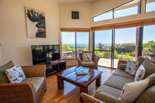 a living room with a couch and a tv and a table at Redgate Beach Escape in Witchcliffe