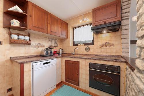 a kitchen with wooden cabinets and a sink and a dishwasher at Apartman Villa Marina in Rakalj