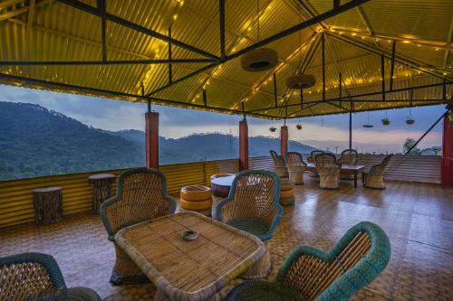 a restaurant with a table and chairs on a balcony at Zostel Homes Harabhag, Jogindernagar in Bīr