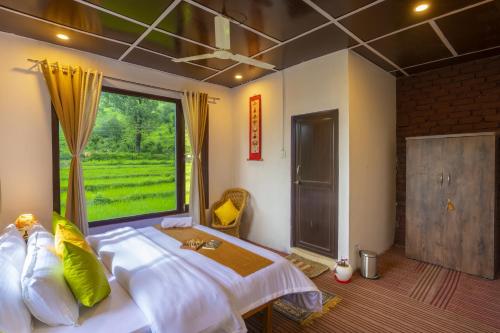 a bedroom with a large bed with a large window at Zostel Homes Harabhag, Jogindernagar in Bīr