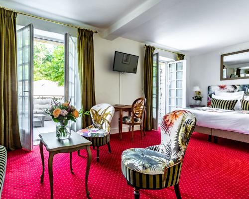 - une chambre avec un lit, une table et des chaises dans l'établissement Hôtel le Centenaire, à Les Eyzies-de-Tayac