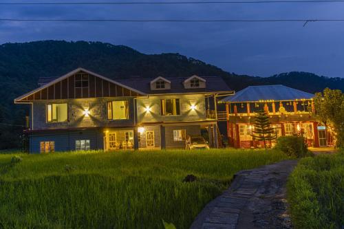 a large house in a field at night at Zostel Homes Harabhag, Jogindernagar in Bīr