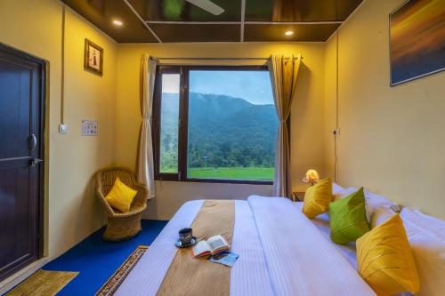 a bedroom with a large bed with a large window at Zostel Homes Harabhag, Jogindernagar in Bīr