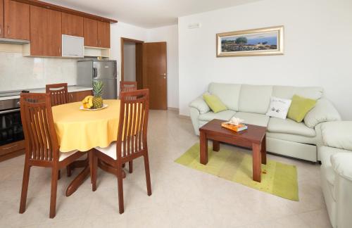 a kitchen and a living room with a table and a couch at Apartments Leon in Podstrana